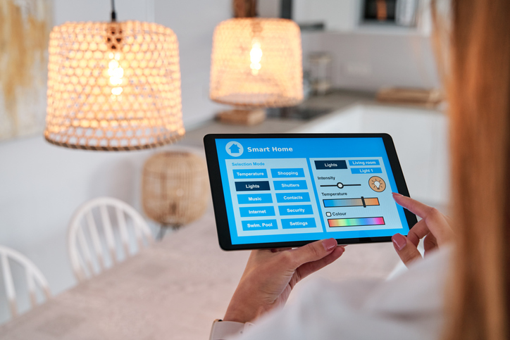 A person controlling smart lights with a handheld device