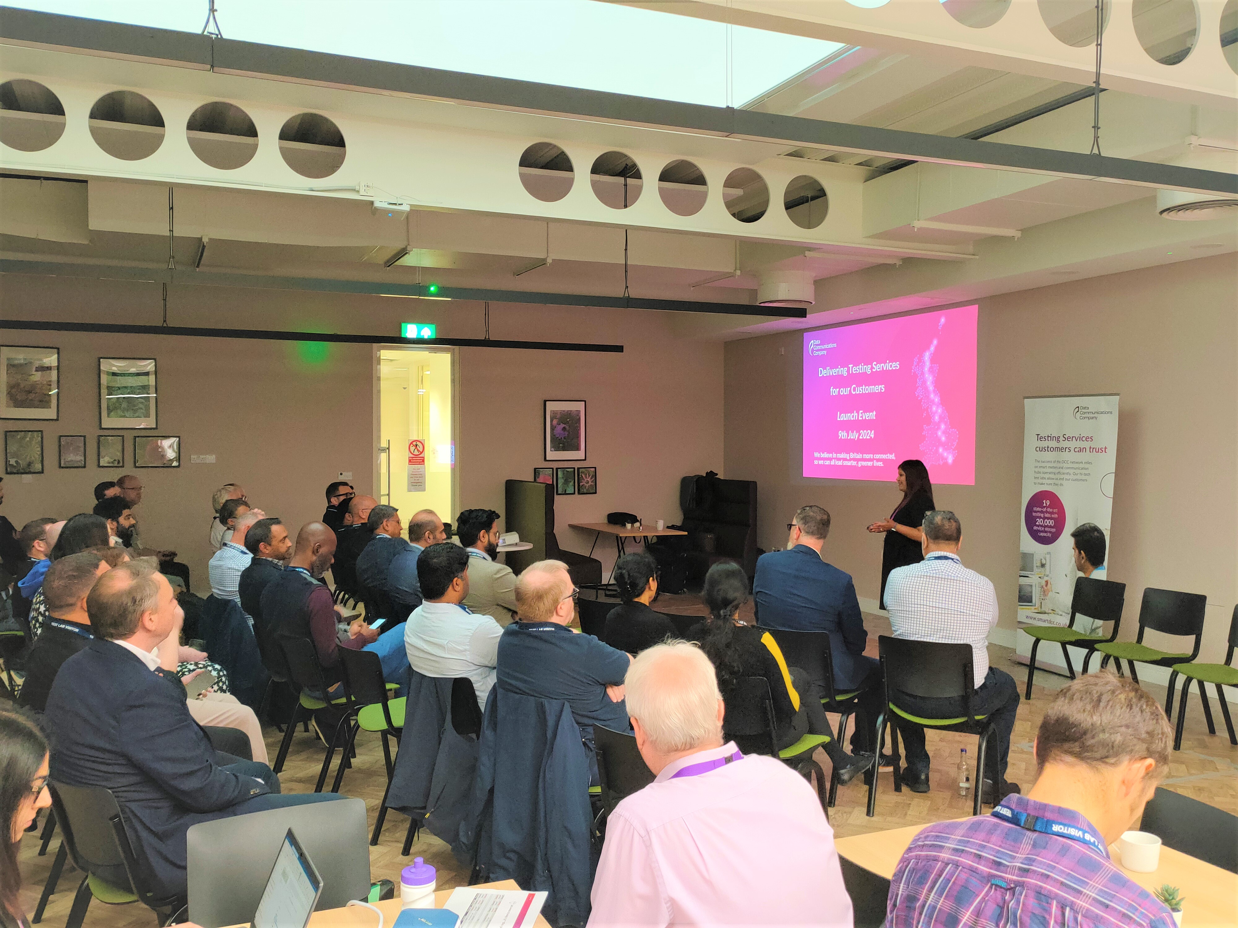 A photograph of Reena Parmar delivering a presentation