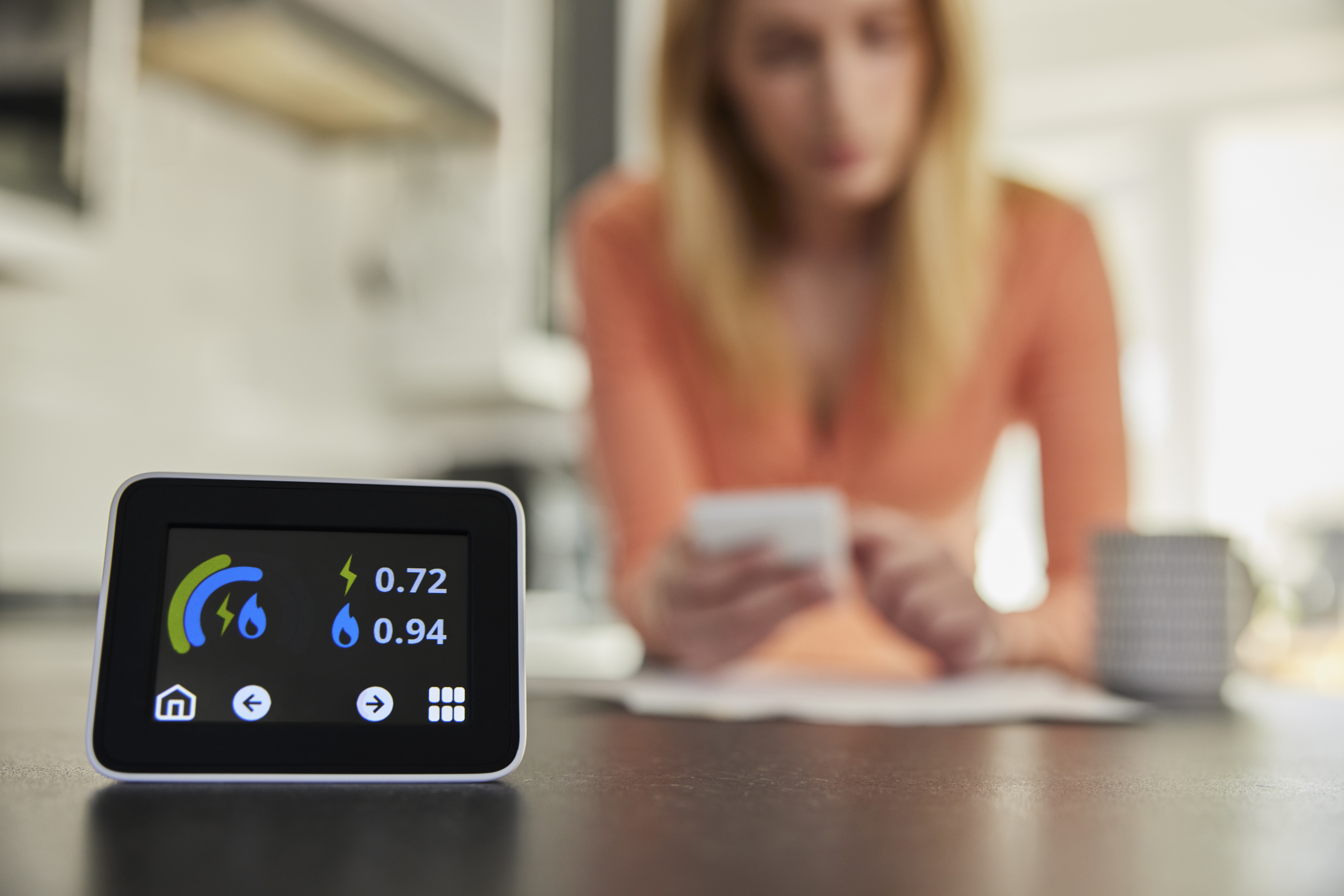Women checking calculator with smart meter in foreground